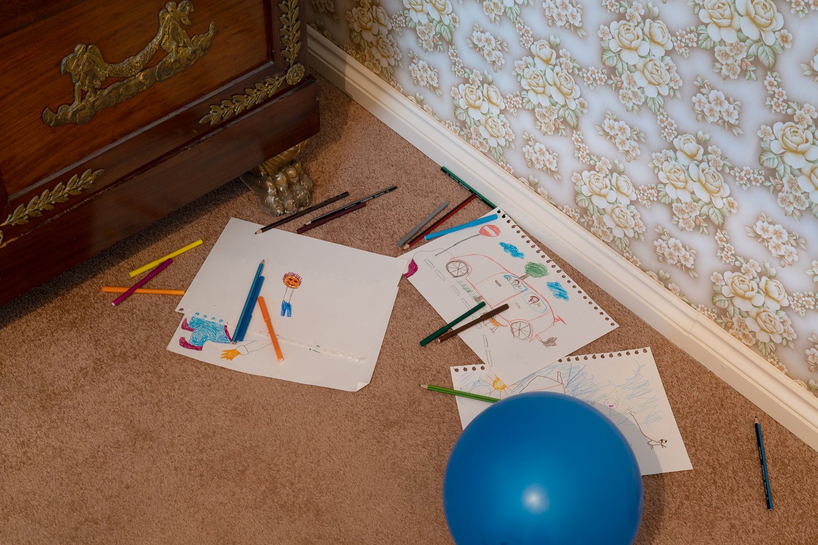 messy floor with children's drawings and scattered pencils